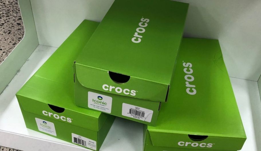 3 green. crocs shoes boxes stacked in a pyramid on a store shelf