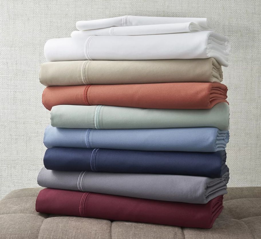 a stack of bed sheets in assorted colors