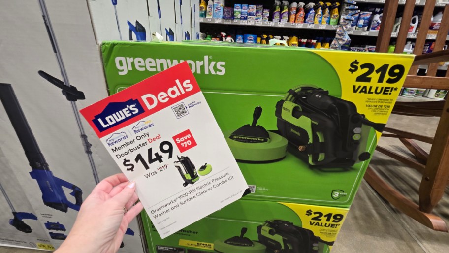 greenworks portable pressure washer in the box, with a hand holding a lowes rewards member sale sign in front of it