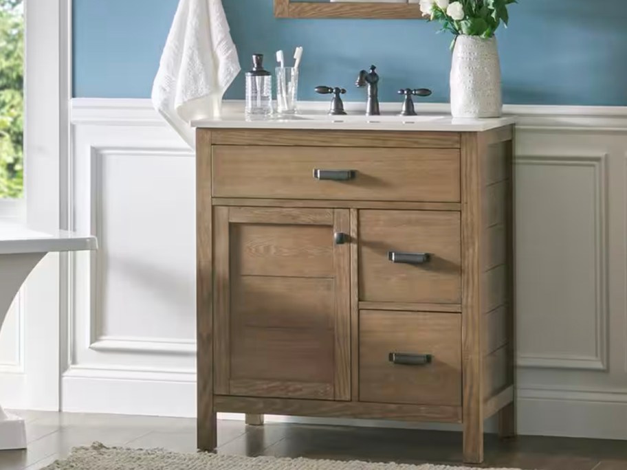 brown bath vanity with flowers on top 