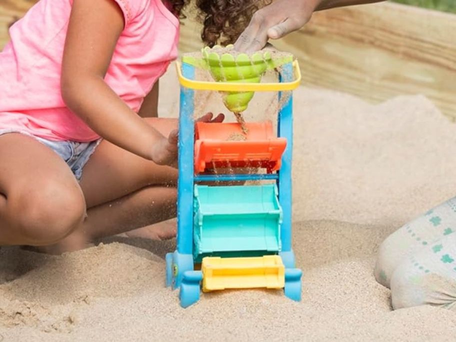 kid playing with Melissa & Doug Seaside Sidekicks Sand-and-Water Sifting Funnel on sand