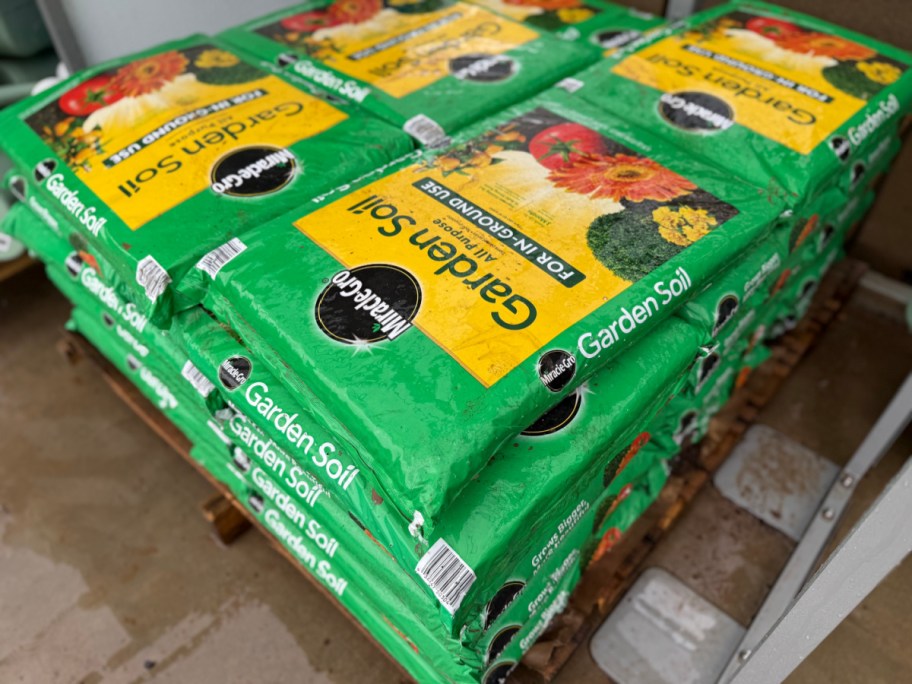 stacked bags of miracle gro garden soil on display in a store
