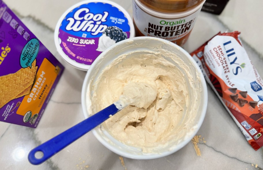 mixing protein powder and cool whip in a bowl 