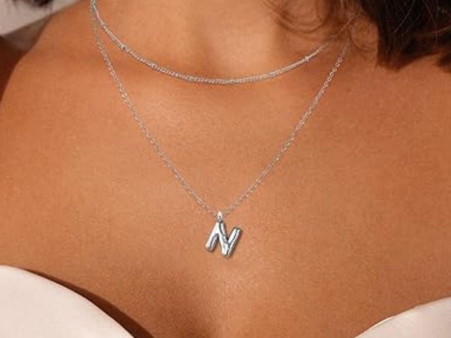 woman wearing initial necklace