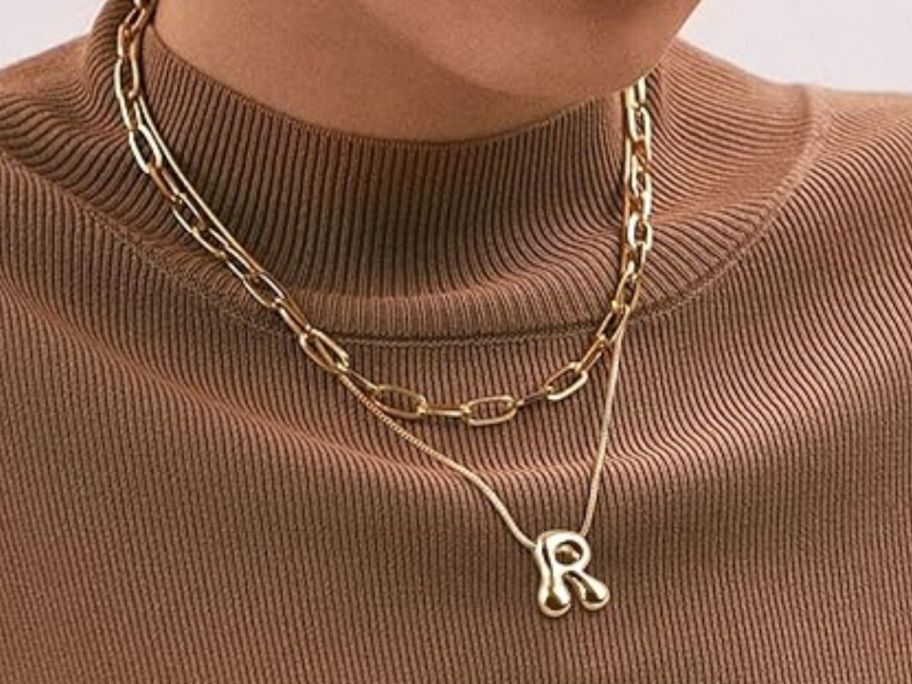 woman wearing initial necklace