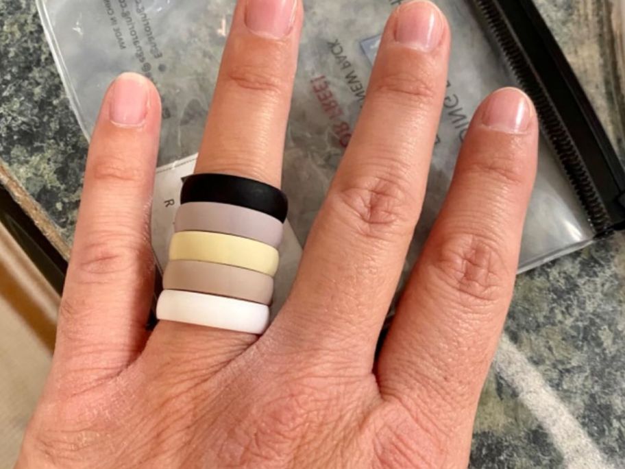 woman wearing five silicone weddings bands on her finger