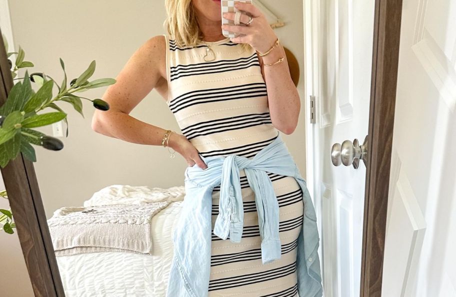 a woman taking a selfie wearing a striped sleeveless sundress