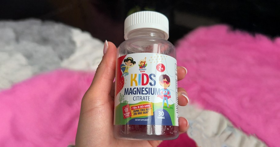 hand holding a bottle of kids gummy vitamins