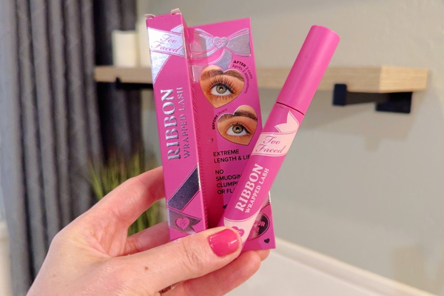 hand holding pink mascara tube and box