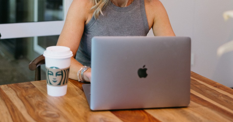 woman working on silver apple macbook while sitting at table