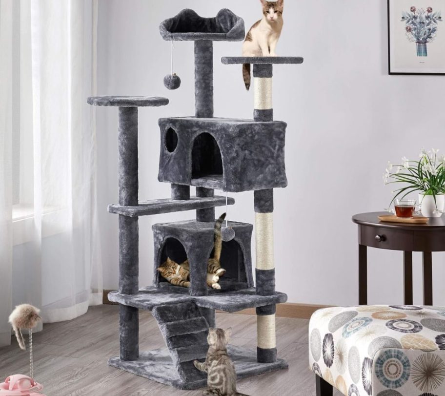 A Topeakmart 54" Multilevel Plush Cat Tree with cats on it