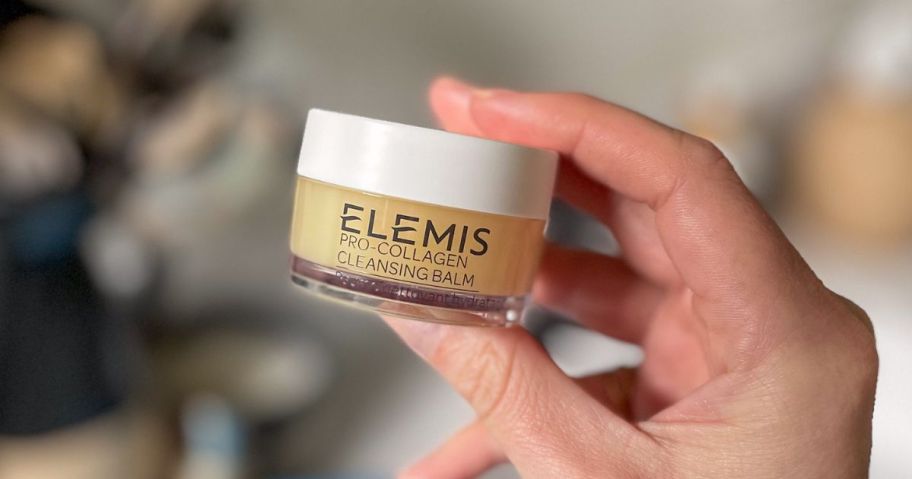 Hand holding a jar of Elemis cleansing Balm