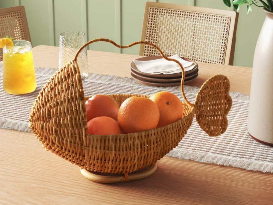 Brown fish shaped basket on a table top filled with oranges