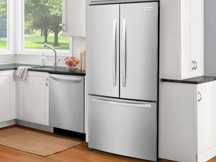 stainless steel Frigidaire fridge and dishwasher in kitchen with white cabinets