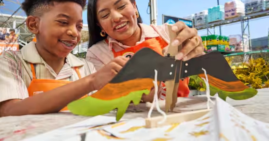 a little boy and a woman making a wooden toucan craft at Home Depot