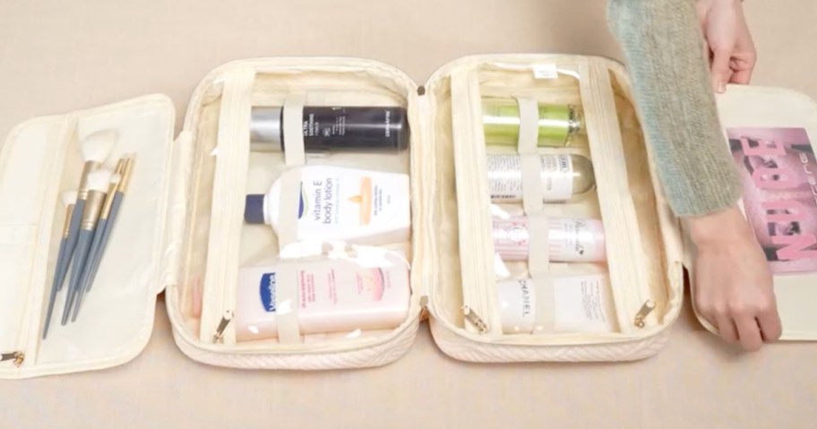 An open Helena Hanging Toiletry bag filled with beauty and personal care products
