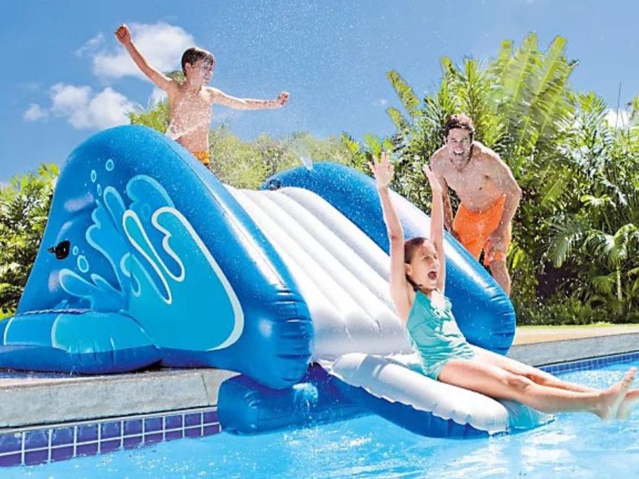 Kids paying in a pool with an inflatable slide