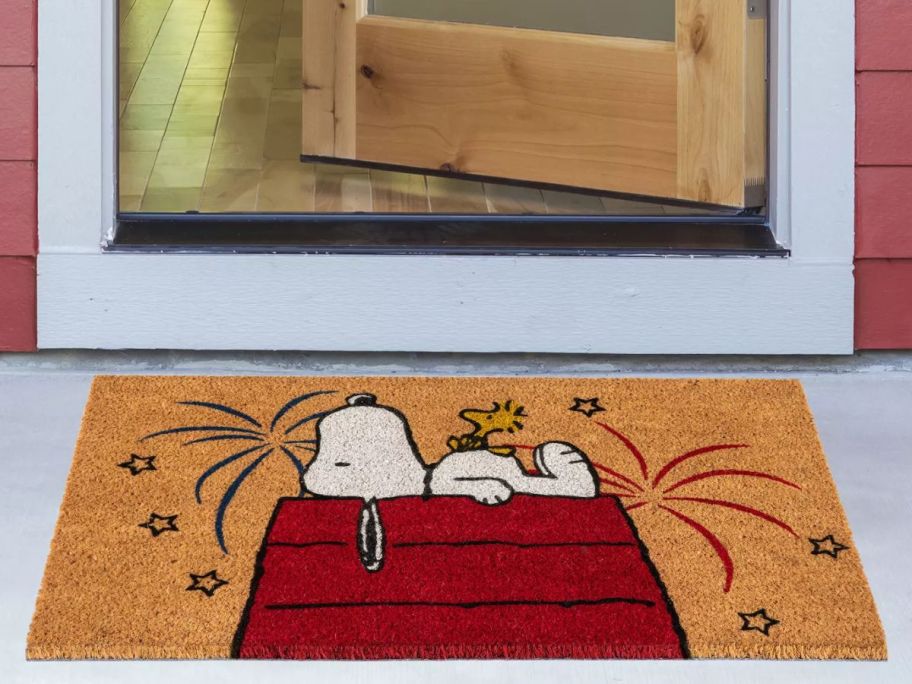 A Snoopy with Fireworks Coir Doormat in front of a door