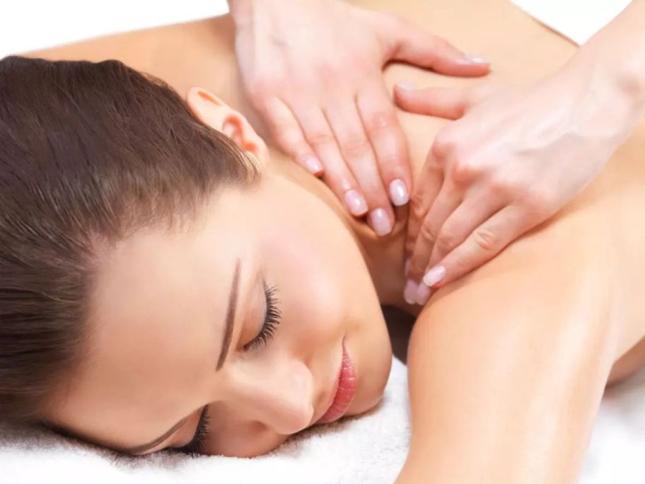 Hands massaging a woman's back and shoulder