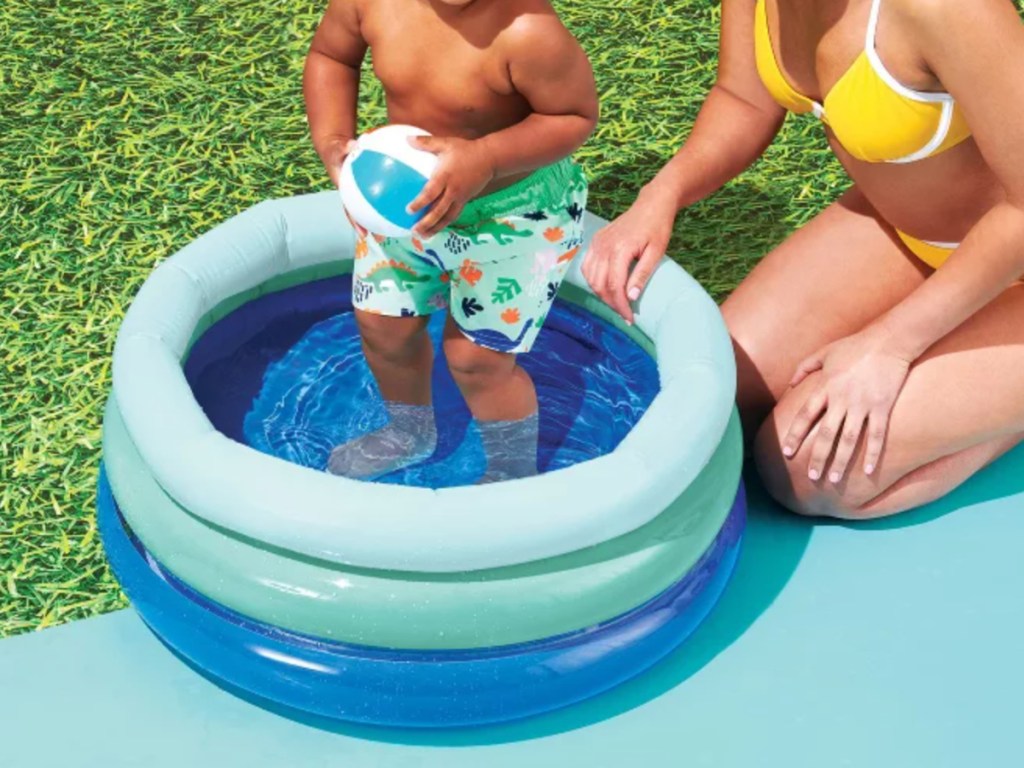 Mini baby pool in blue with baby standing in pool