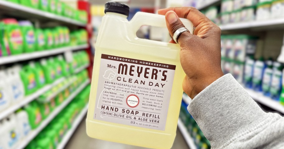 hand holding up a Mrs. Meyer's Hand Soap Refill bottle in laundry aisle of store