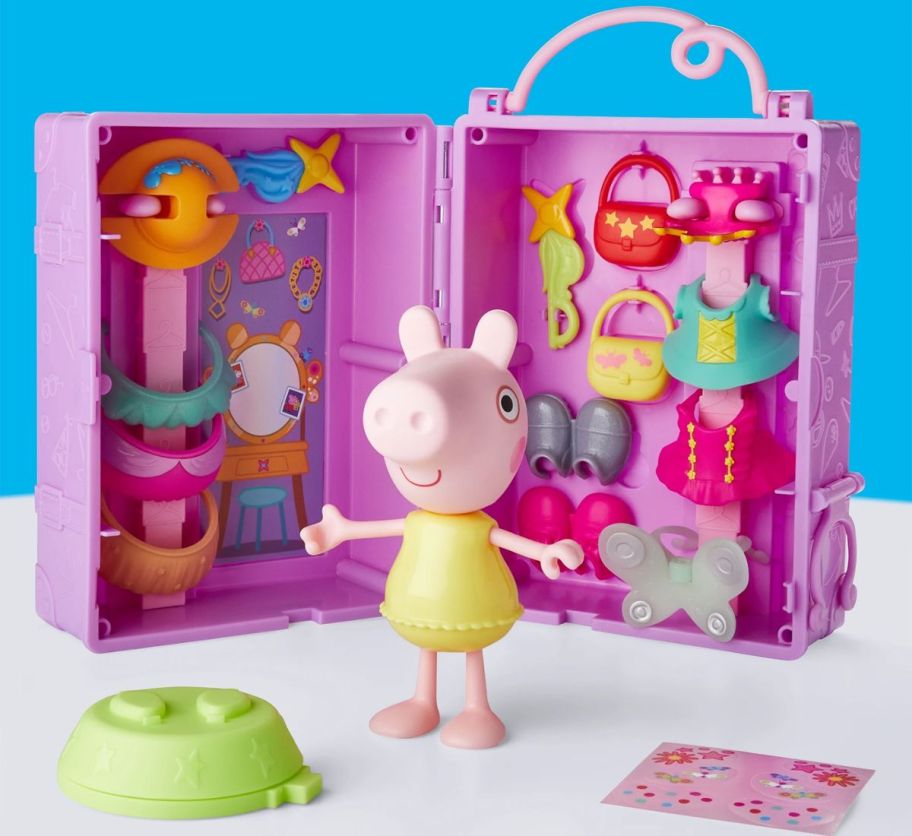 a peppa pig figure shown with clothing, accessories and storage case/ wardrobe