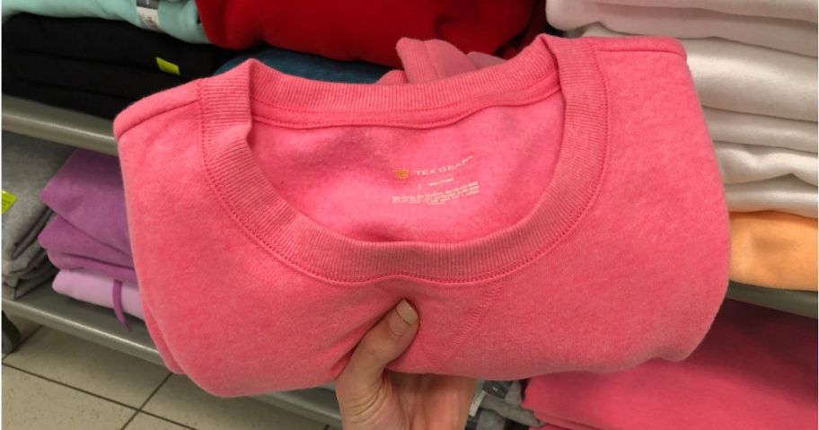 Hand holding a pink Tek Gear Sweatshirt