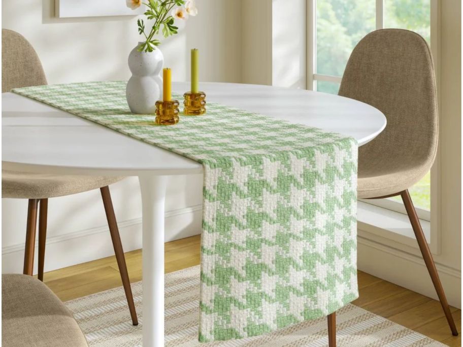 Houndstooth table runner in green on a round table with chairs next to it 