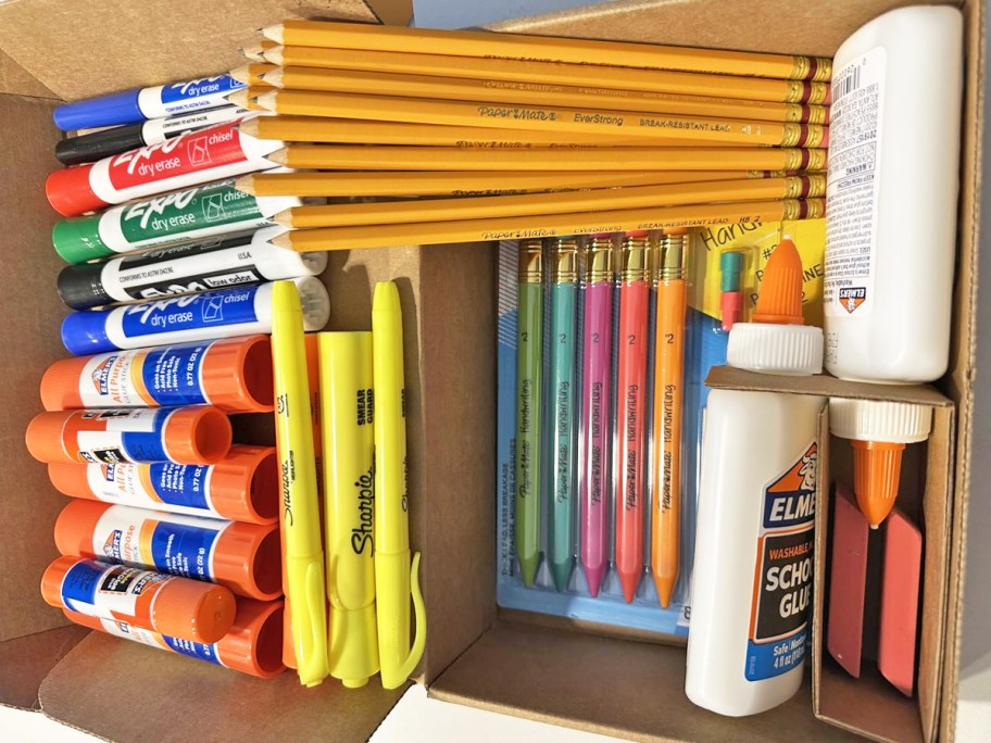 various school supplies in a cardboard box