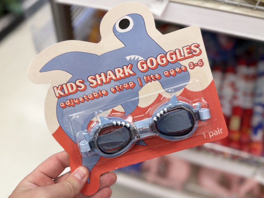 hand holding a set of shark goggles in store