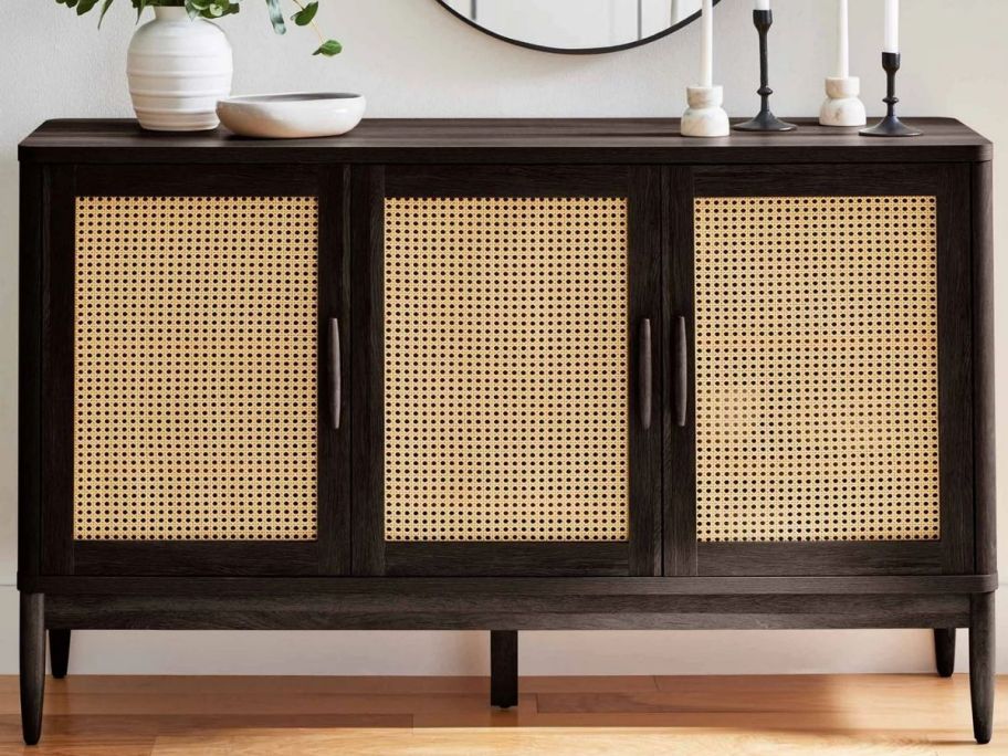 a dark wood and caning styled sideboard with 3 doors