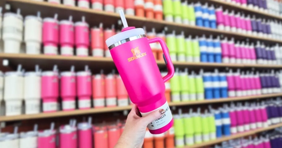 a woman hand holding a hot pink 40oz stanley tumbler