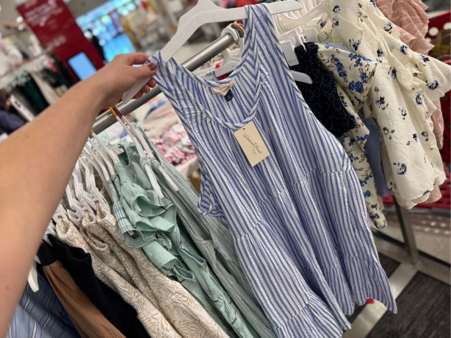 Hand holding up a Universal Thread Women's Mini Sundress on a hanger