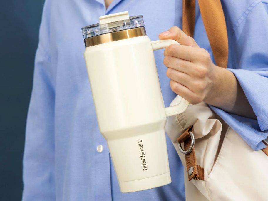 A woman holding a Thyme & Table Tumbler in Cream 
