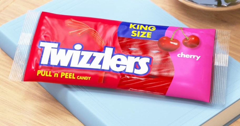 bag of Twizzlers Pull 'N' Peel candy on top of a blue book