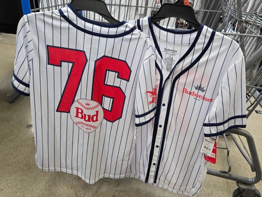 Budweiser Men's Baseball Jerseys hanging on cart in store