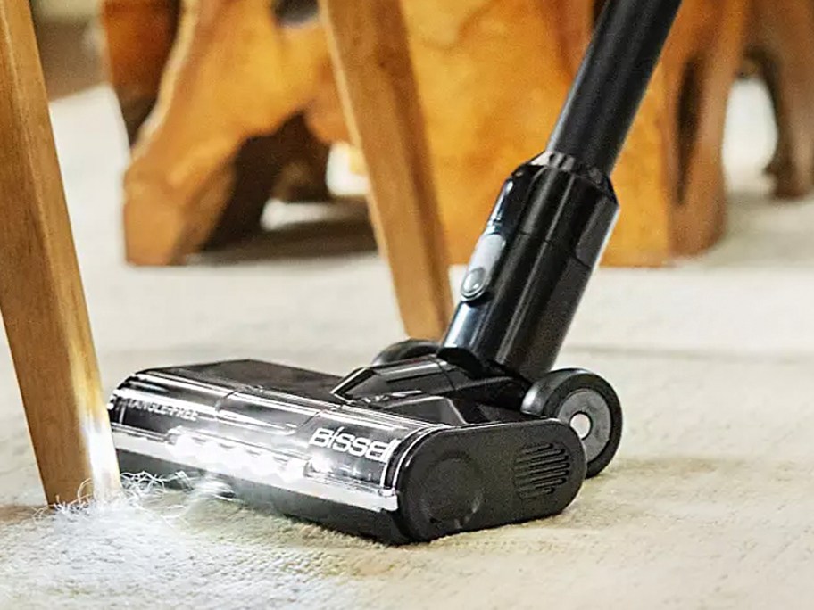 black vacuum cleaning floor with light on 