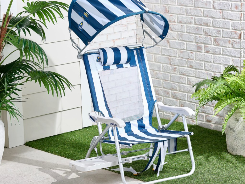 blue and white striped beach chair next to palm tree