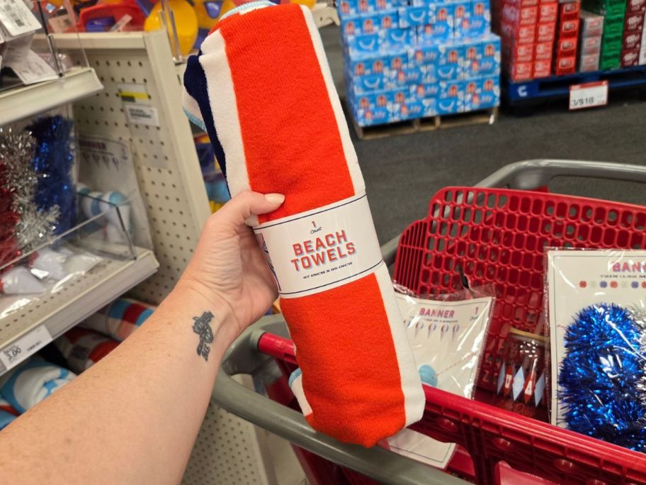 rolled up red and white Beach Towel in hand in store