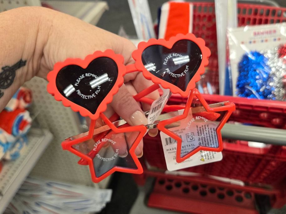 red heart-shaped and star-shaped sunglasses in hand in store