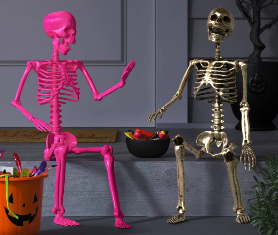 a hot pink and a gold posable skeletons on a porch