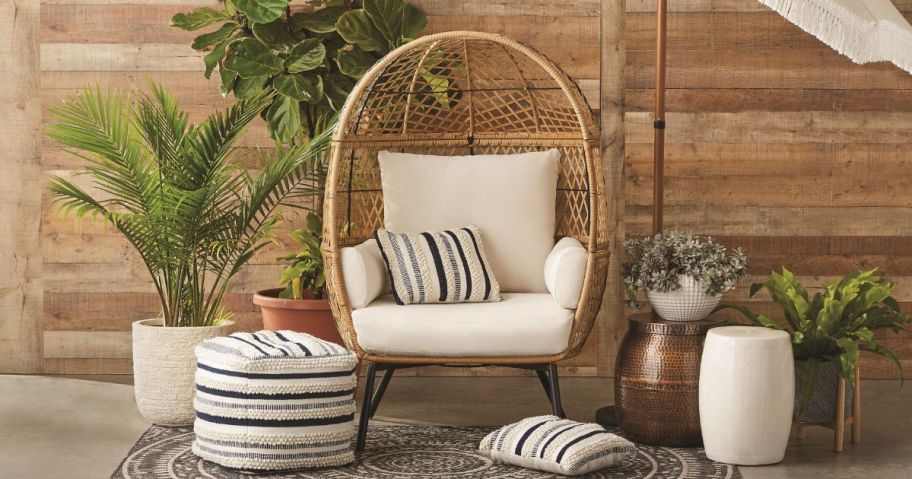 Better Homes & Gardens Ventura Boho Outdoor Wicker Egg Chair in indoor patio with pillows around it