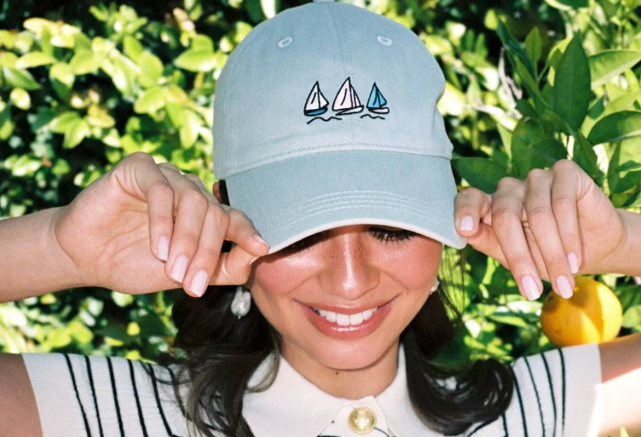 woman wearing a blue hat with embroidered sail boats