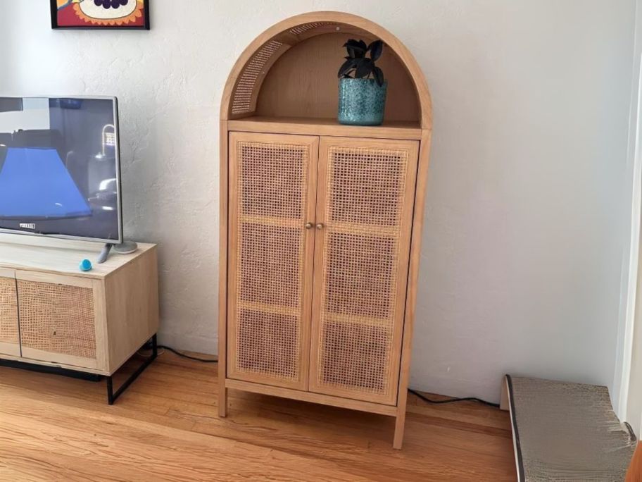 light brown Threshold Woven Arched Wood Cabinet against wall