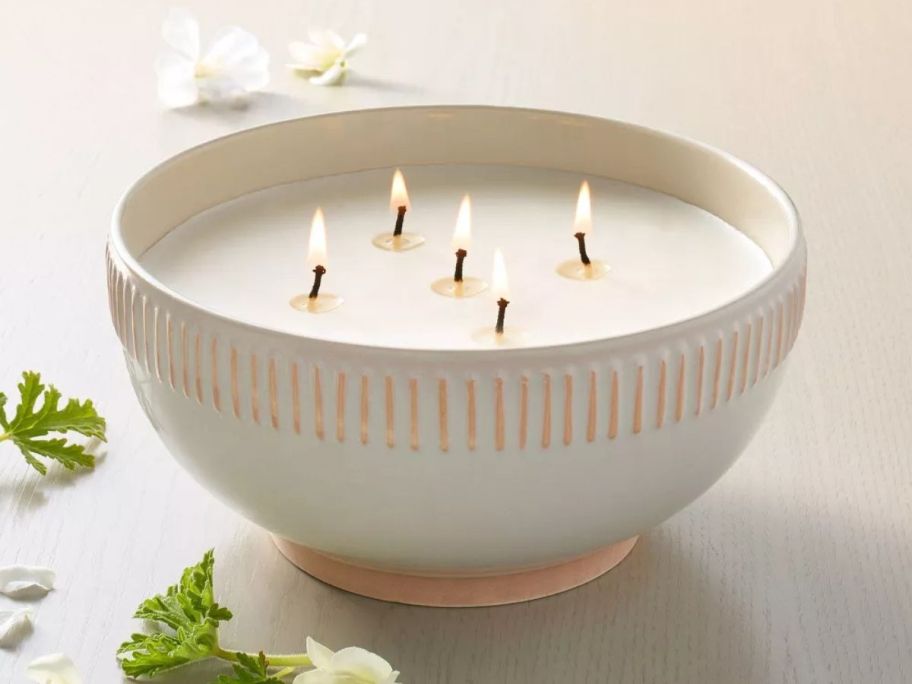 a lit Hearth & Hand with Magnolia Rim 32oz Stripe Ceramic Citronella Scented Bowl Candle on table