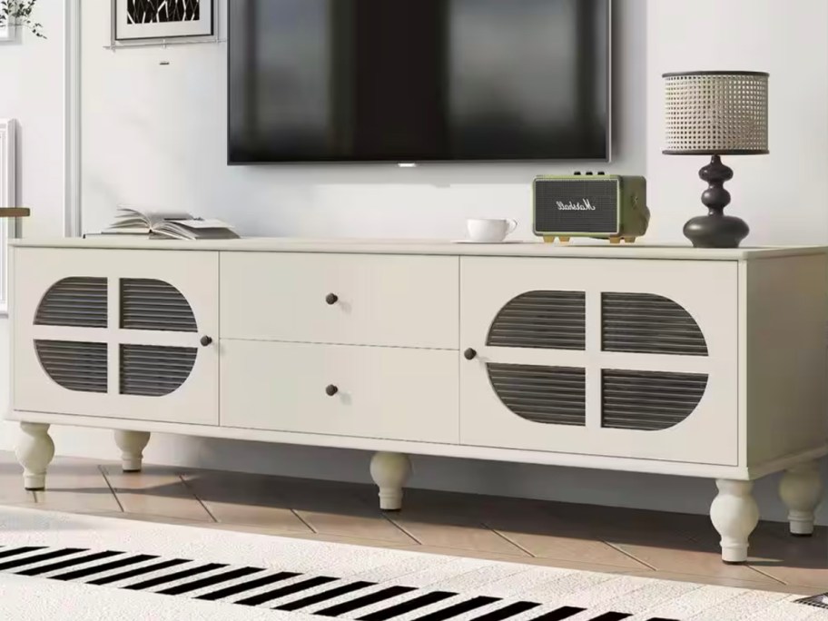 white tv stand with tv on wall above it 
