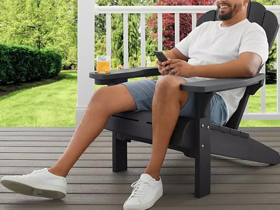 man sitting in gray adirondak chair