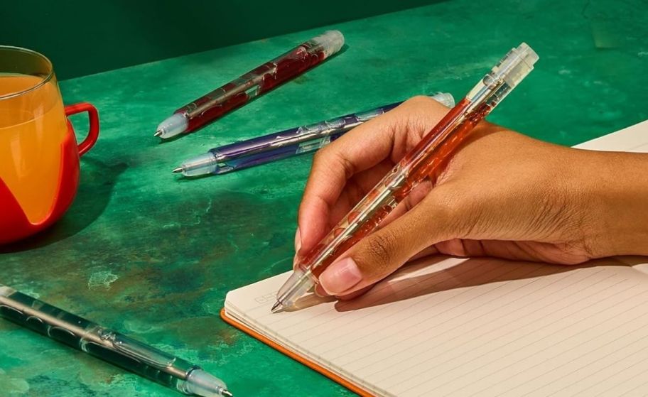 a womans hand writing with a lava pen