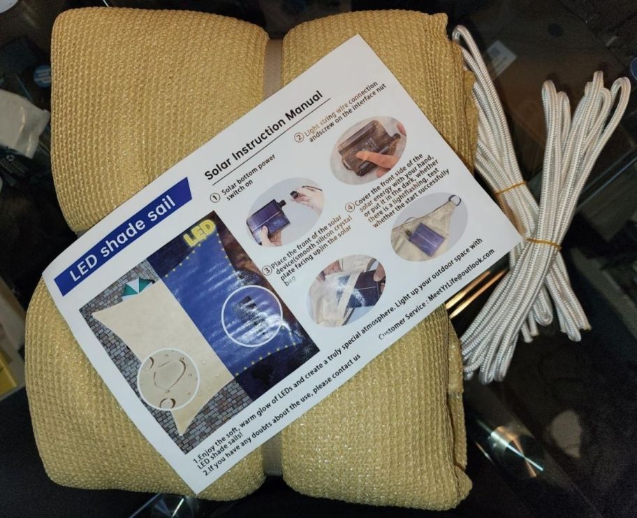 a folded shade sail shown with solar led power paCKck strings and instructions