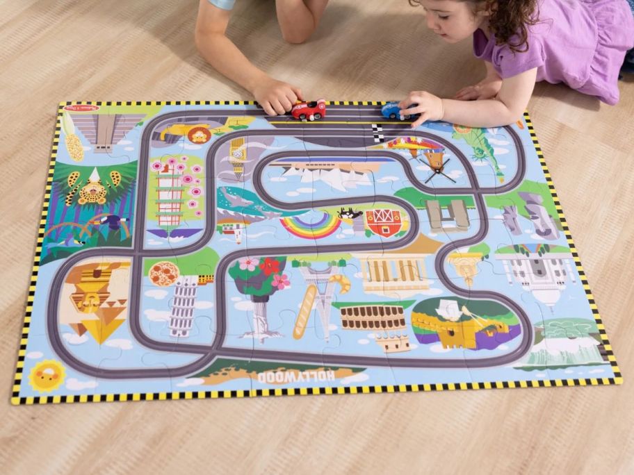 kids playing with Melissa & Doug Race Around The World Tracks Cardboard Jigsaw Floor Puzzle on floor